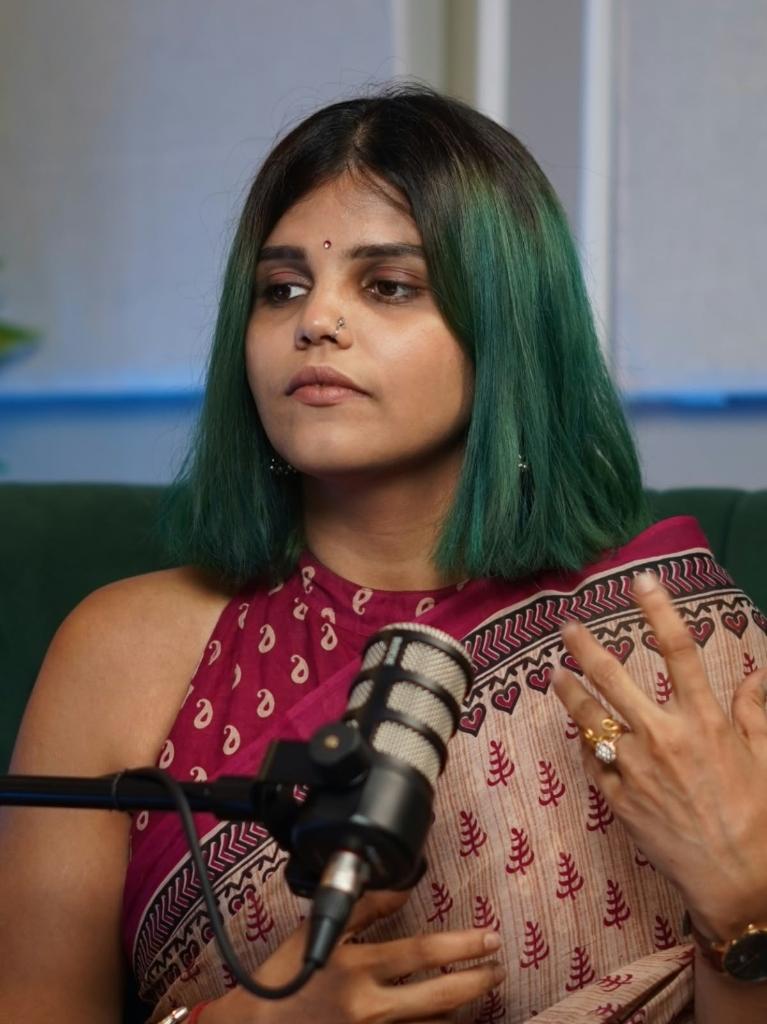 Harshita Dagha recording a podcast episode in her studio with broadcast microphone